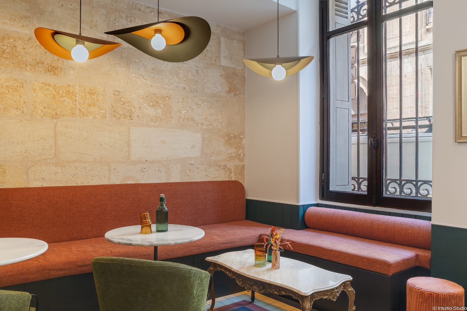 Mur de pierre blonde et banquette du salon de thé Lalère